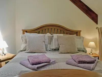 a bed with two purple pillows on top of it at Golygfar Mynydd - Mountain View in Strata Florida