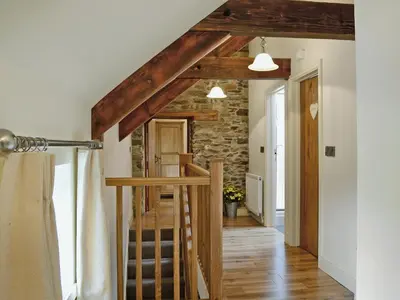 a staircase in a house with wooden beams at Golygfar Mynydd - Mountain View in Strata Florida