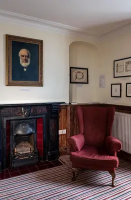 a living room with a red chair and a fireplace at Y Talbot in Tregaron