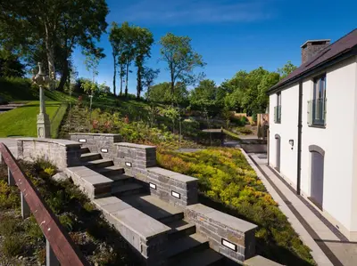 a garden with stone steps next to a building at Y Talbot in Tregaron