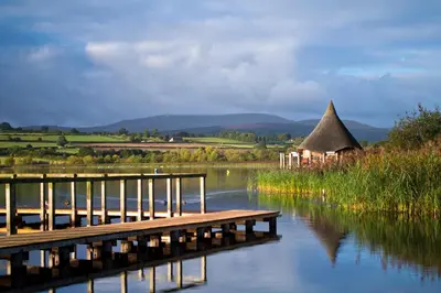 a dock on a body of water with a hut at Brynderwen Barn in Llangorse