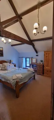 a bedroom with a large bed in a room at Brynderwen Barn in Llangorse
