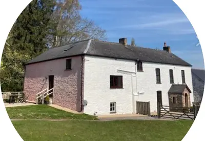a large white building with a black roof at Brynderwen Barn in Llangorse