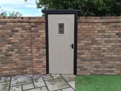 a white door in a brick wall at Shrewsbury Cottage in Shrewsbury