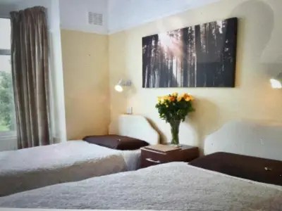 a hotel room with two beds and a vase of flowers at Shrewsbury Cottage in Shrewsbury