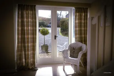 an open door with a chair and a plant outside at Rhiwddu Barns in Llangadog