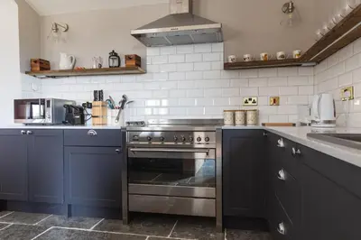 a kitchen with blue cabinets and a stove at Gaer Fawr Barns in Guilsfield