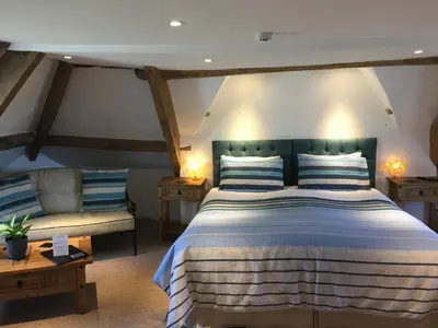 a bedroom with a large bed and a couch at Aberllynfi Riverside Guest House in Glasbury
