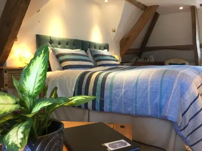 a bedroom with a bed with a blue and white bedspread at Aberllynfi Riverside Guest House in Glasbury