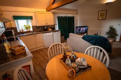 a kitchen and living room with a table and a couch at Irfon Cottage in Builth Wells