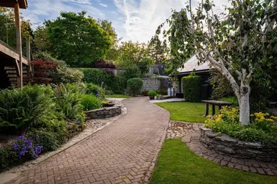 a garden with a brick walkway in a yard at Irfon Cottage in Builth Wells