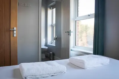 two towels on a bed in a room with a window at Mid Wales Holiday Lets, Rhayader in Rhayader