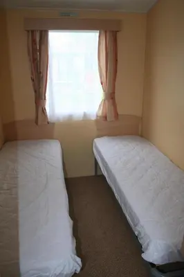 two beds in a small room with a window at Dinas in Llanbedr