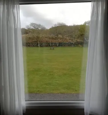 a window with a view of a field of grass at Dinas in Llanbedr