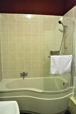 a bathroom with a tub and a towel on the wall at The Red Lion in Llangadog