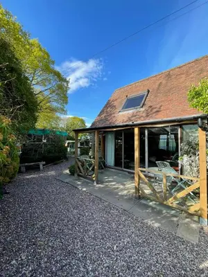 a barn with a roof and a building at Parrs cottage in Wollaston