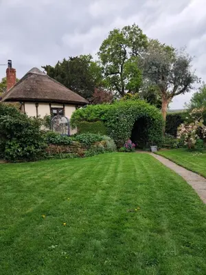 a house with a green yard with a grass field at Parrs cottage in Wollaston