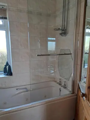 a bathroom with a bath tub with a mirror at Parrs cottage in Wollaston