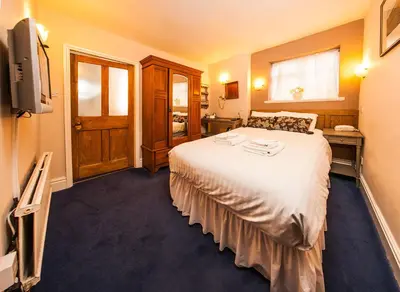 a hotel room with a bed and a television at Gales Of Llangollen in Llangollen