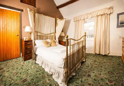 a bedroom with a canopy bed and a window at Gales Of Llangollen in Llangollen