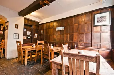a restaurant with wooden walls and wooden tables and chairs at Gales Of Llangollen in Llangollen