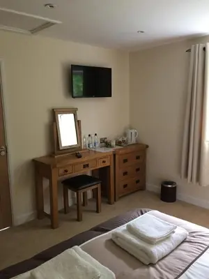 a bedroom with a desk and a mirror and a bed at Bryn Derwen in Rhayader