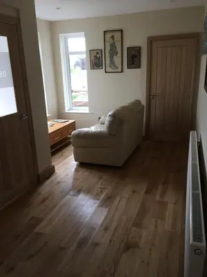 a living room with a couch and a wooden floor at Bryn Derwen in Rhayader