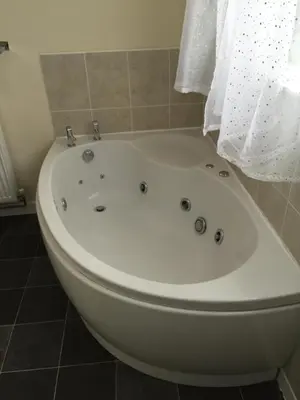 a white bath tub sitting in a bathroom at Bryn Derwen in Rhayader