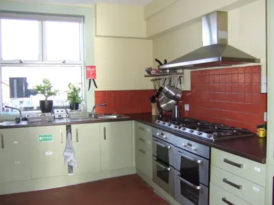 a kitchen with a sink and a stove top oven at Llangollen Hostel - Book Whole Room - Self Catering Facilities in Llangollen