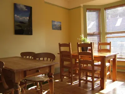 a dining room with a wooden table and chairs at Llangollen Hostel - Book Whole Room - Self Catering Facilities in Llangollen