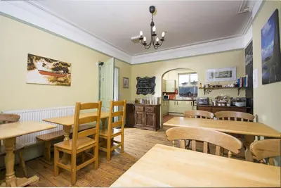 a dining room with wooden tables and chairs at Llangollen Hostel - Book Whole Room - Self Catering Facilities in Llangollen