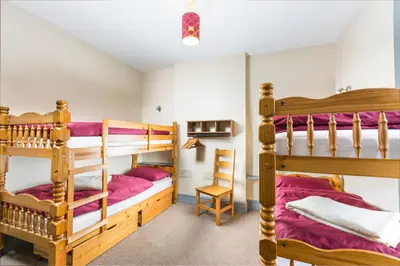 a bedroom with two bunk beds and a desk at Llangollen Hostel - Book Whole Room - Self Catering Facilities in Llangollen