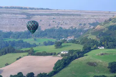 a hot air balloon flying over a green field at Llangollen Hostel - Book Whole Room - Self Catering Facilities in Llangollen