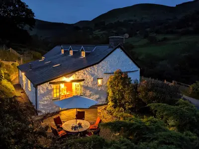 a house with a table and chairs in front of it at Ty'n Y Ffordd in Llanymawddwy