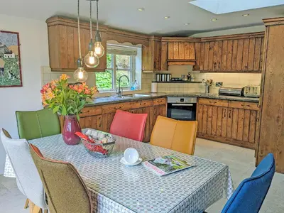 a kitchen with a table with chairs and a vase on it at Ty'n Y Ffordd in Llanymawddwy