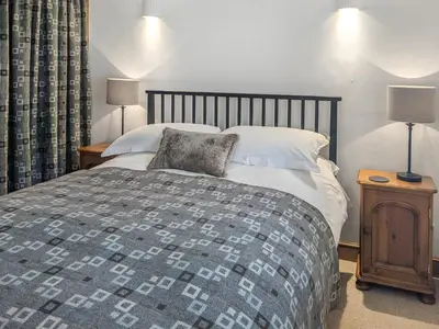 a bedroom with a large bed and two lamps at Ty'n Y Ffordd in Llanymawddwy