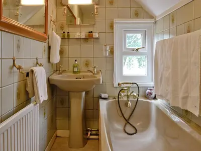 a bathroom with a sink and a bath tub and a sink at Y Bwthyn in Bala