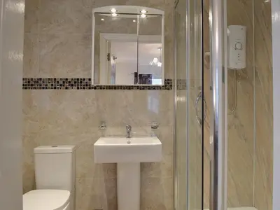 a bathroom with a sink and a toilet and a mirror at Maes Rheidol in Capel Bangor