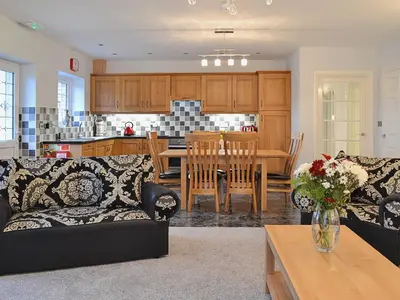 a living room and kitchen with a couch and a table at Maes Rheidol in Capel Bangor