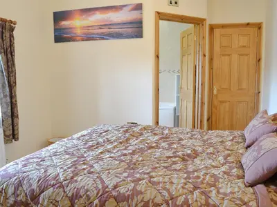 a bedroom with a bed and a picture on the wall at 5 Pengraig Draw in Llanychaiarn