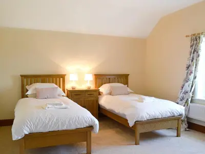 a bedroom with two beds and a window at Cefnaire in Newtown