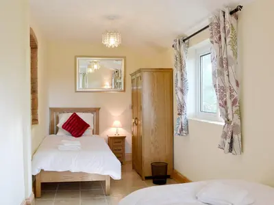 a bedroom with two beds and a mirror at Cefnaire in Newtown
