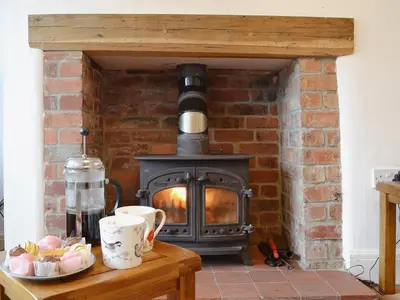 a brick fireplace with a wood stove in it at The Old Post Office in Myddfai
