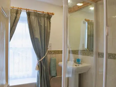 a bathroom with a shower curtain and a sink at The Old Post Office in Myddfai
