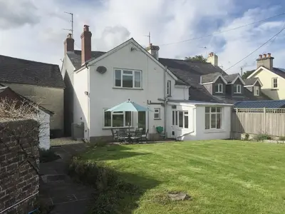 a white house with a lawn in front of it at The Old Post Office in Myddfai