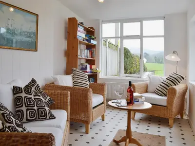 a living room with wicker chairs and a table at The Old Post Office in Myddfai