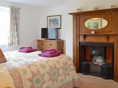 a bedroom with a bed with purple pillows on it at The Old Post Office in Myddfai