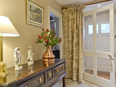a vase of flowers on a dresser in a room at Friary Cottage in Ludlow