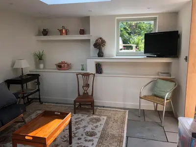 a living room with a tv and a table and chairs at Friary Cottage in Ludlow
