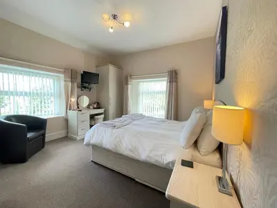 a bedroom with a bed and a desk and a chair at Bwch yn Uchaf B&B in Llanuwchllyn